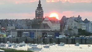 A harbor with boats and a building with a tower.