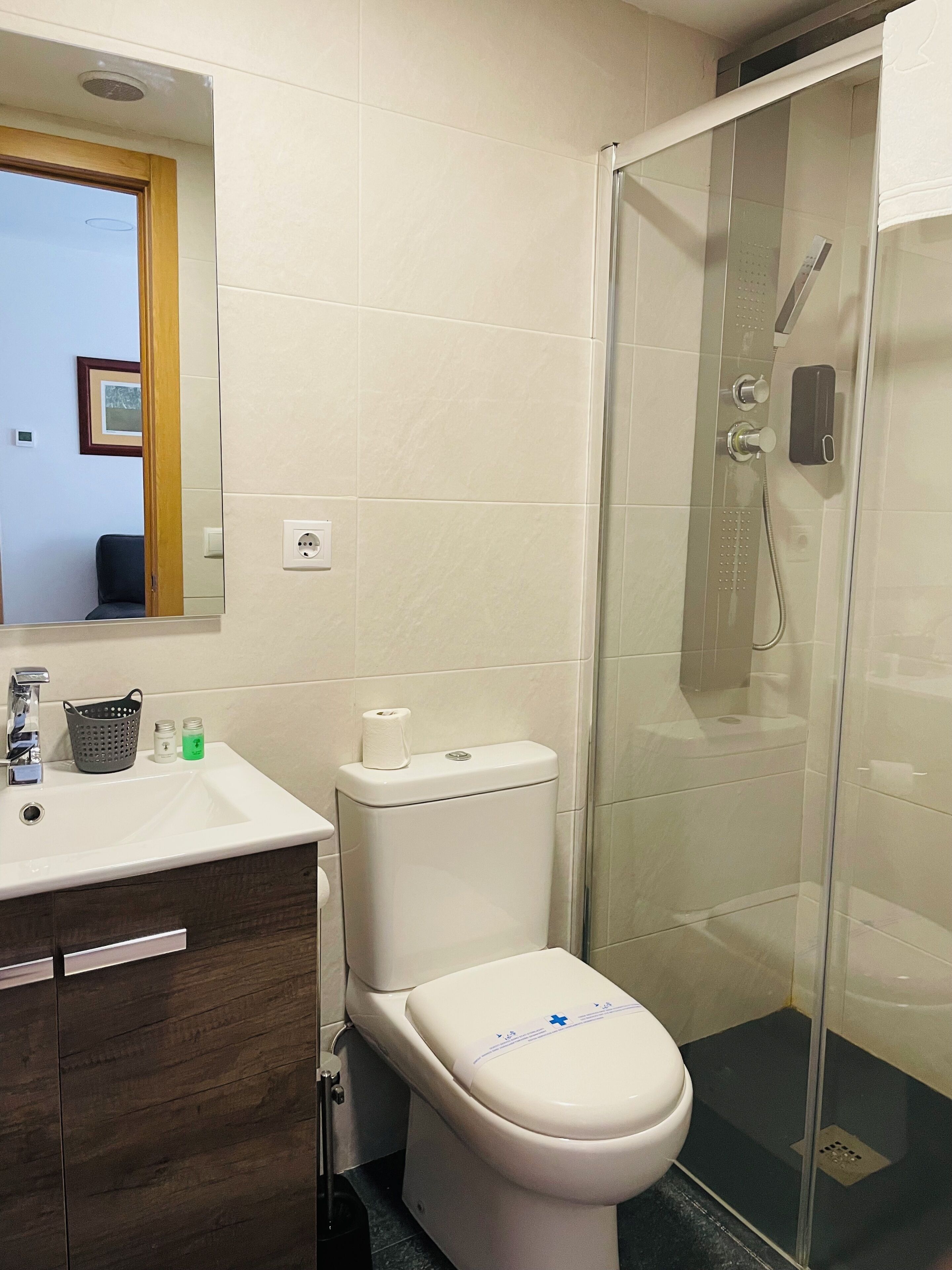 Une salle de bain équipée de toilettes, d’un lavabo et d’une douche.