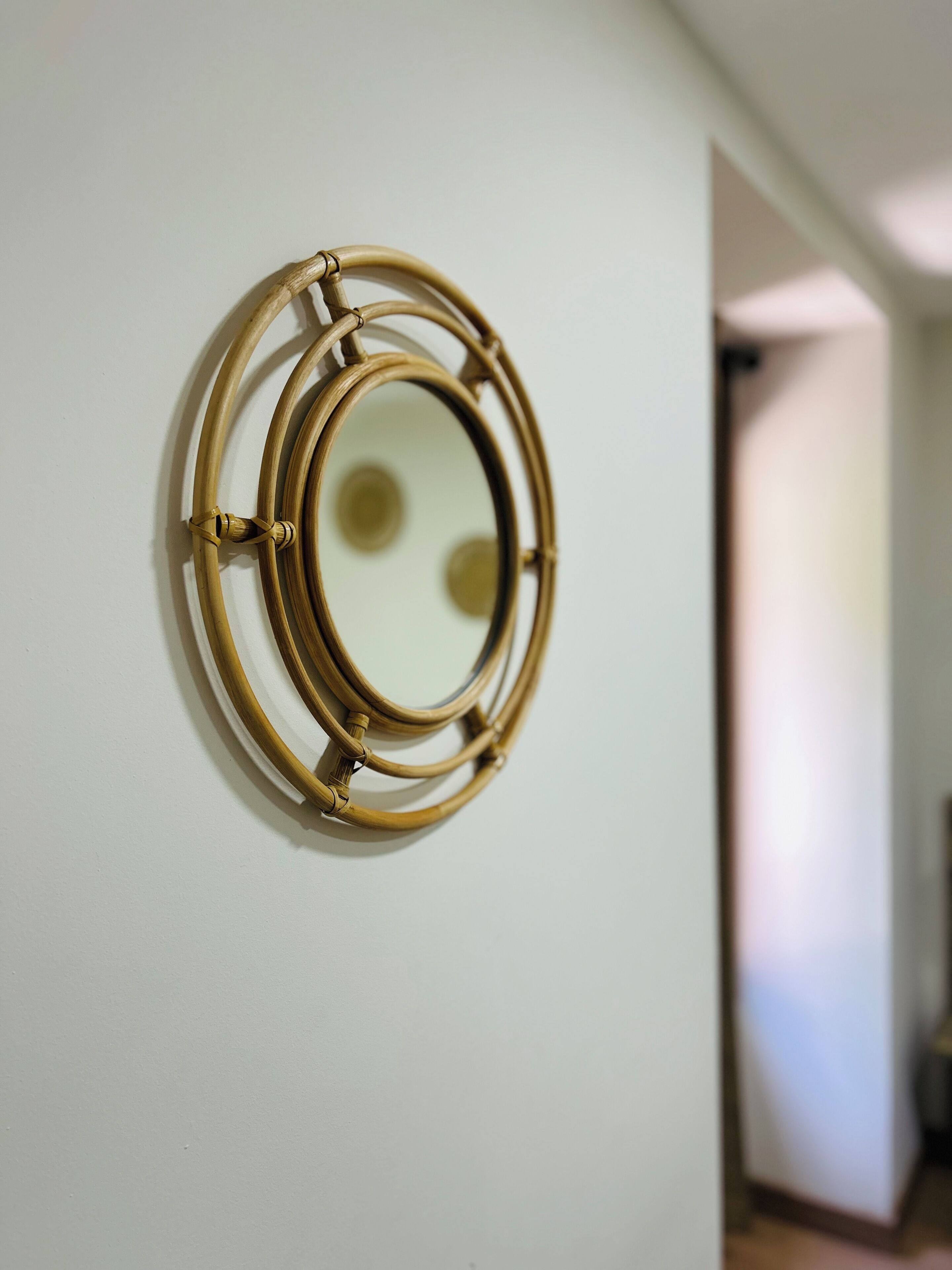 A wall-mounted circular mirror with a gold frame.