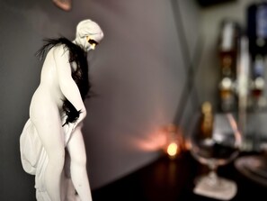 A room with a white statue, a candle, and a shelf with bottles. - Croydon Cozy Retreat - 2 Bedroom Luxury Home (South Croydon)