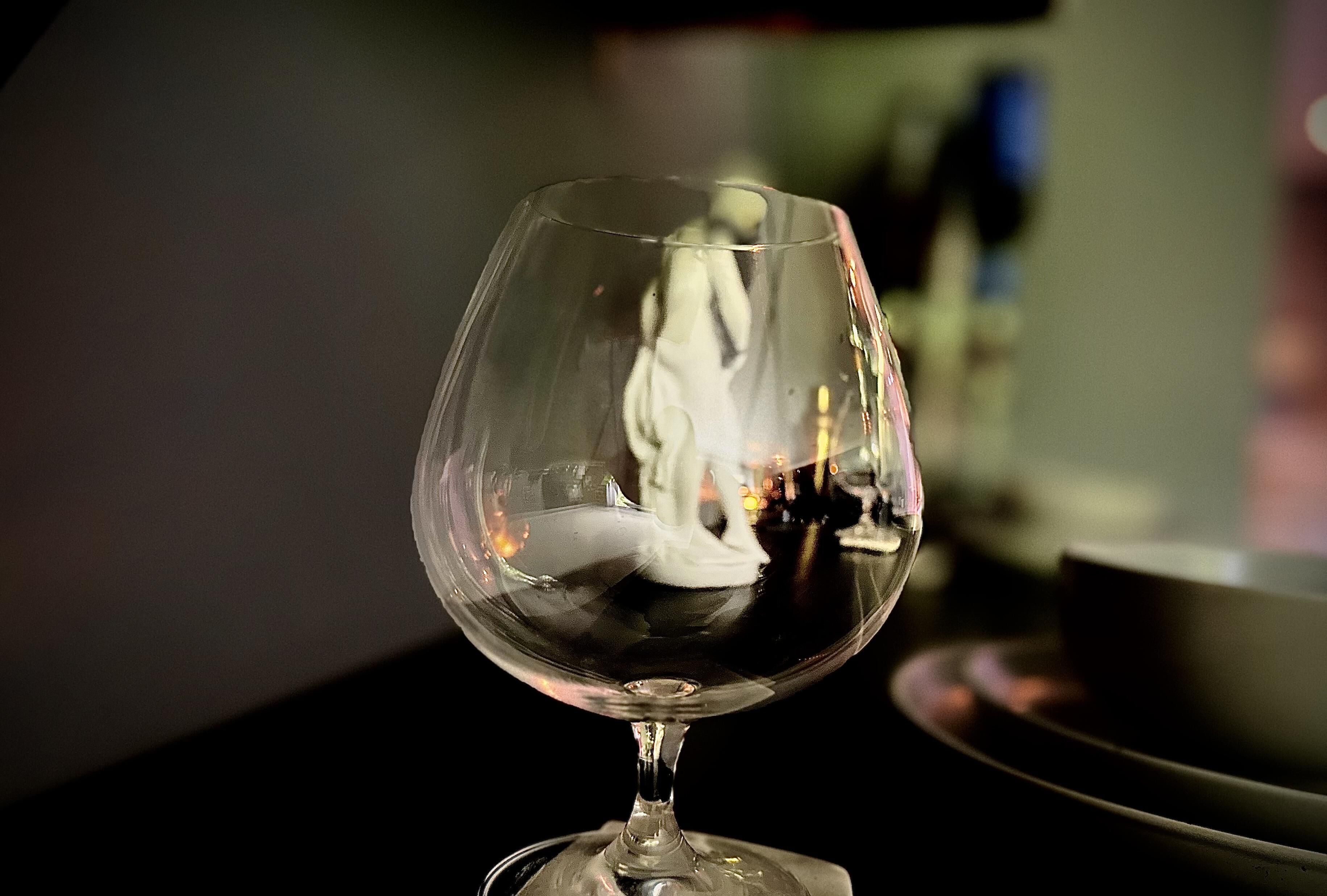 Un verre à vin en verre transparent, posé sur une table, avec un arrière-plan flou.