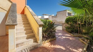 A residential area with a staircase leading to a building, surrounded by greenery and a clear sky. - 3895 RSM - Appartamento Ester by Barbarhouse (Manduria)