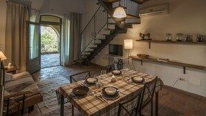 Un comedor con mantel a cuadros, una escalera y un colgador de techo.