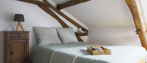 Un dormitorio con cama, un armario de madera y una mesita de noche.