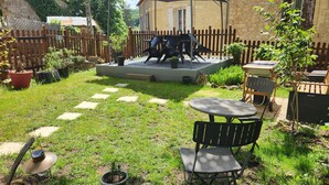 Un espace extérieur aménagé avec une table et des chaises, une petite scène et une clôture en bois.