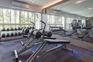 A gym with exercise equipment, dumbbells, and a large mirror. - Kantary Hotel, Amata Bangpakong (Chon Buri)