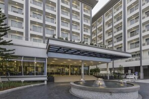 A multi-story hotel with a covered entrance, a central fountain, and a parking area. - Kantary Hotel, Amata Bangpakong (Chon Buri)
