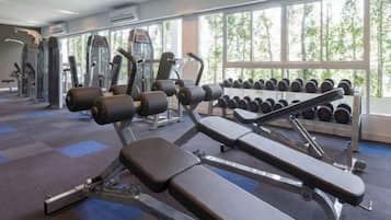 A gym with exercise equipment and dumbbells.