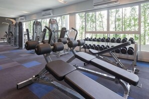 A gym with exercise equipment, dumbbells, and large windows. - Kantary Hotel, Amata Bangpakong (Chon Buri)