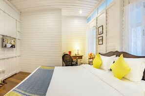 Una habitación de hotel con cama, escritorio, silla y televisión.