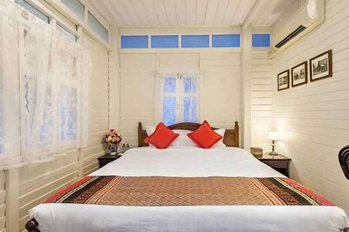 Classic design with a large bed, wooden headboard, and traditional ceiling.