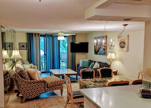 Relax in a spacious living room with a large flat-screen TV, dining area, and comfortable seating.
