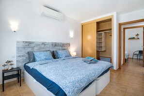A bedroom with a bed, bedside table, nightstand, and a wooden wardrobe. - 'Mi Casita' with Mountain View, Private Terrace and Wi-Fi (Playa Blanca)