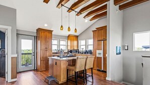 Een moderne keuken met houten kastjes, een centraal eiland en hanglampen.