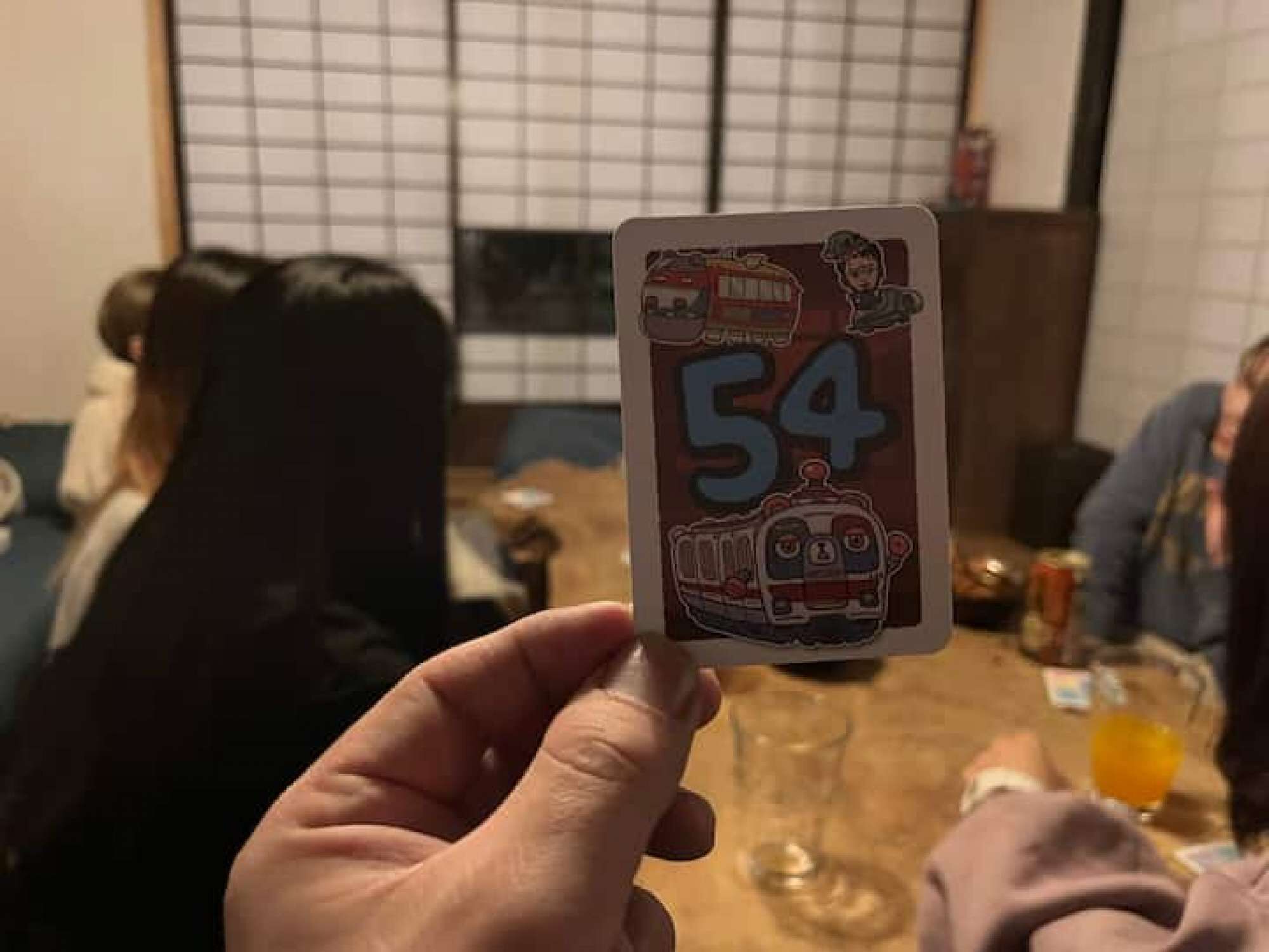 Una persona che tiene un carte da gioco con il numero 54.