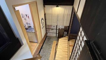 A staircase with a wooden handrail and a black wall on one side.