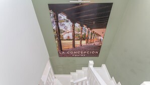 Una escalera con barandillas blancas que lleva a una habitación con pared verde y un cartel de un edificio.