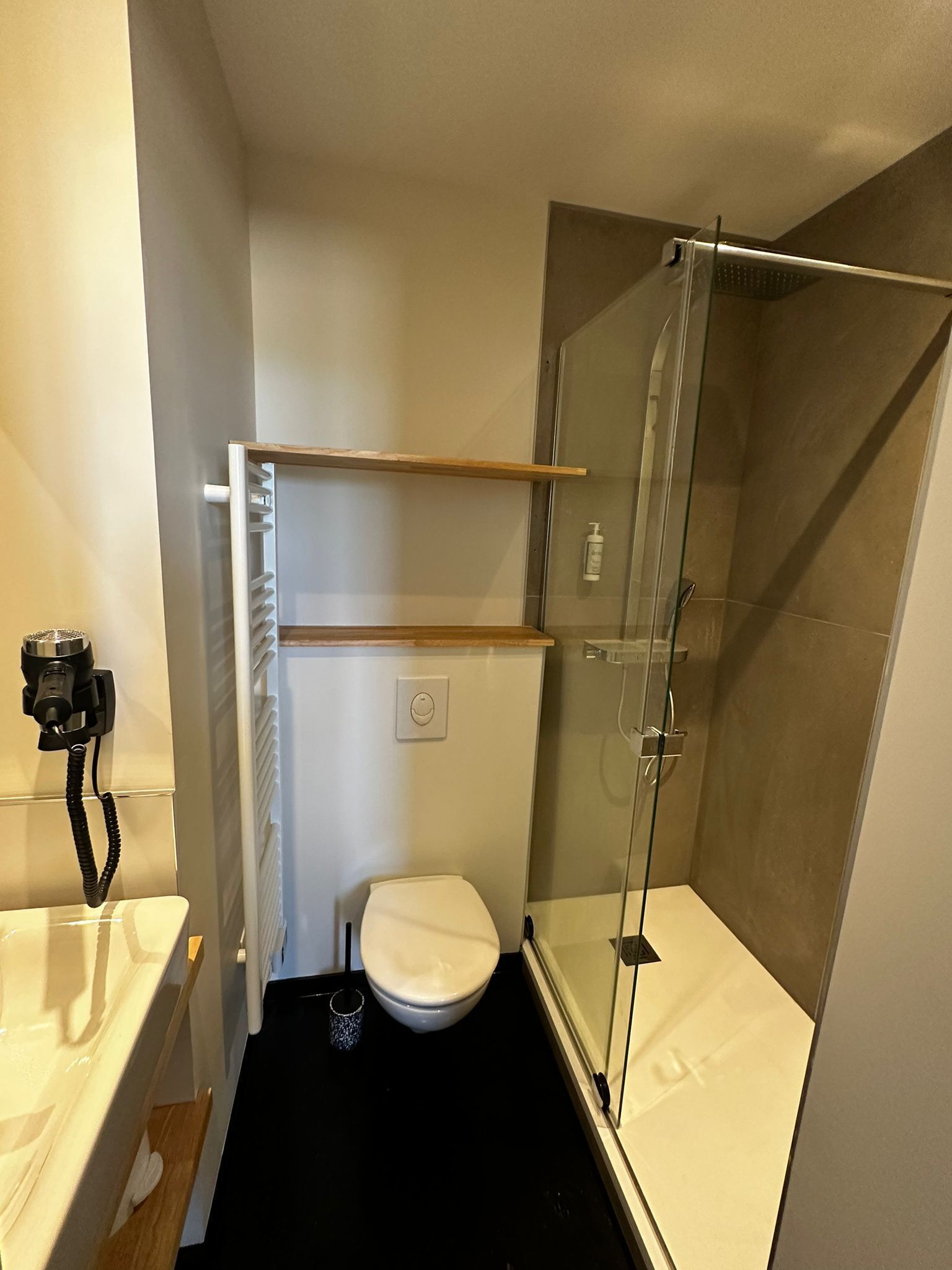 Un baño pequeño con inodoro, cabina de ducha de vidrio y barra para toallas.