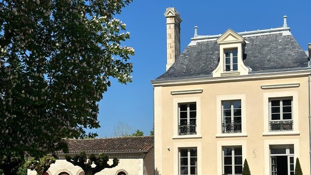 A large, two-story building with a symmetrical facade, multiple windows, and a central chimney. - Domaine de l'Ecorcerie (Liguge)