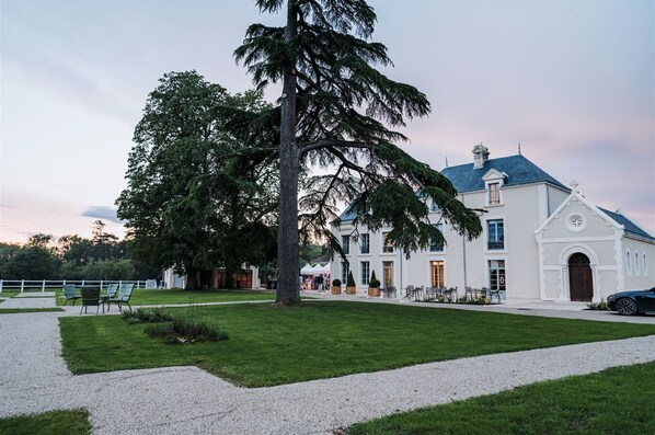 A large white building with a steep roof and a prominent tree in front. - Domaine de l'Ecorcerie (Liguge)