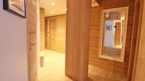 Un pasillo con paneles de madera y una pequeña ventana con un marco de foto.