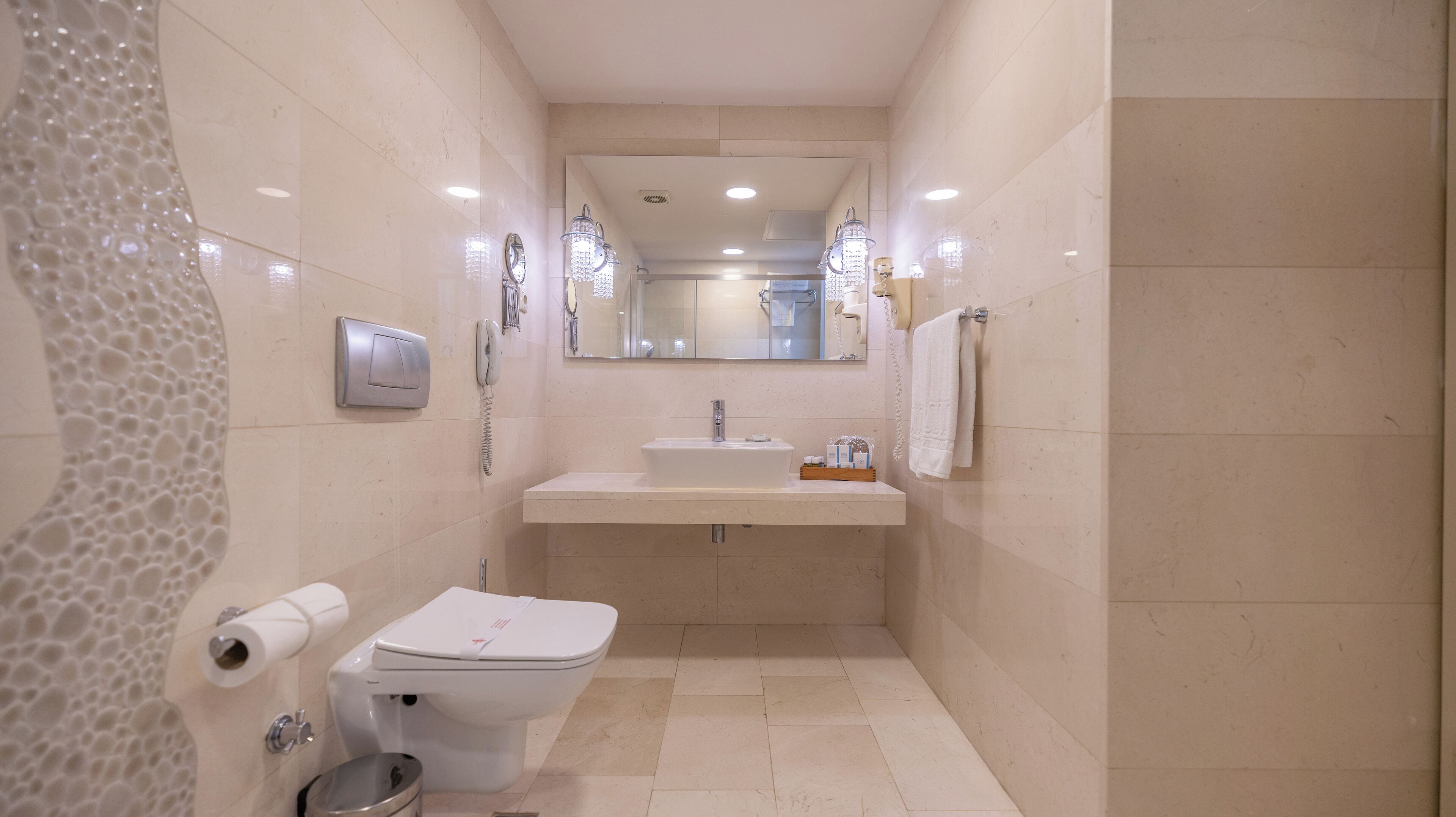 Un baño pequeño con inodoro, lavamanos y ducha.