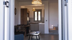 An open sliding door leading into a modern kitchen with a dining area. - Filia Skyros Suites (Skiros)