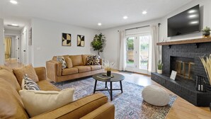Ein modernes Wohnzimmer mit Sofa, Couchtisch und Kamin.