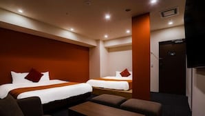 A hotel room with two beds, a sofa, a coffee table, and a TV. - Randor Hotel Sapporo Suites (Sapporo)