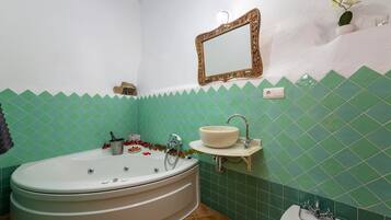 Un bagno con una vasca freestanding, un lavabo su piedistallo e uno specchio a parete.