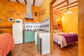 A compact room with a bed, a small kitchenette, and a bathroom. - Holiday Home 'Casa Rural Jaraiz Vip' with Mountain View, Shared Pool and Wi-Fi (Laroya)