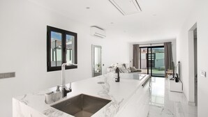 Una cucina moderna con un piano di lavoro in marmo, un lavello e un'ampia finestra.