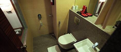A small bathroom with a toilet, sink, and a mirror.
