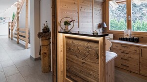 A modern kitchen with wooden cabinetry, a central island, and a view of the outdoors.
