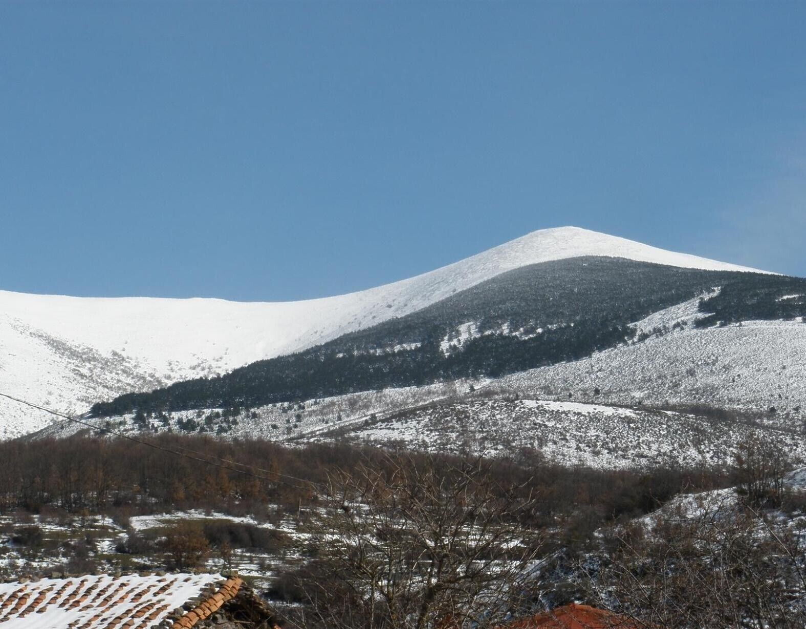 A snow-covered mountain with a clear sky.