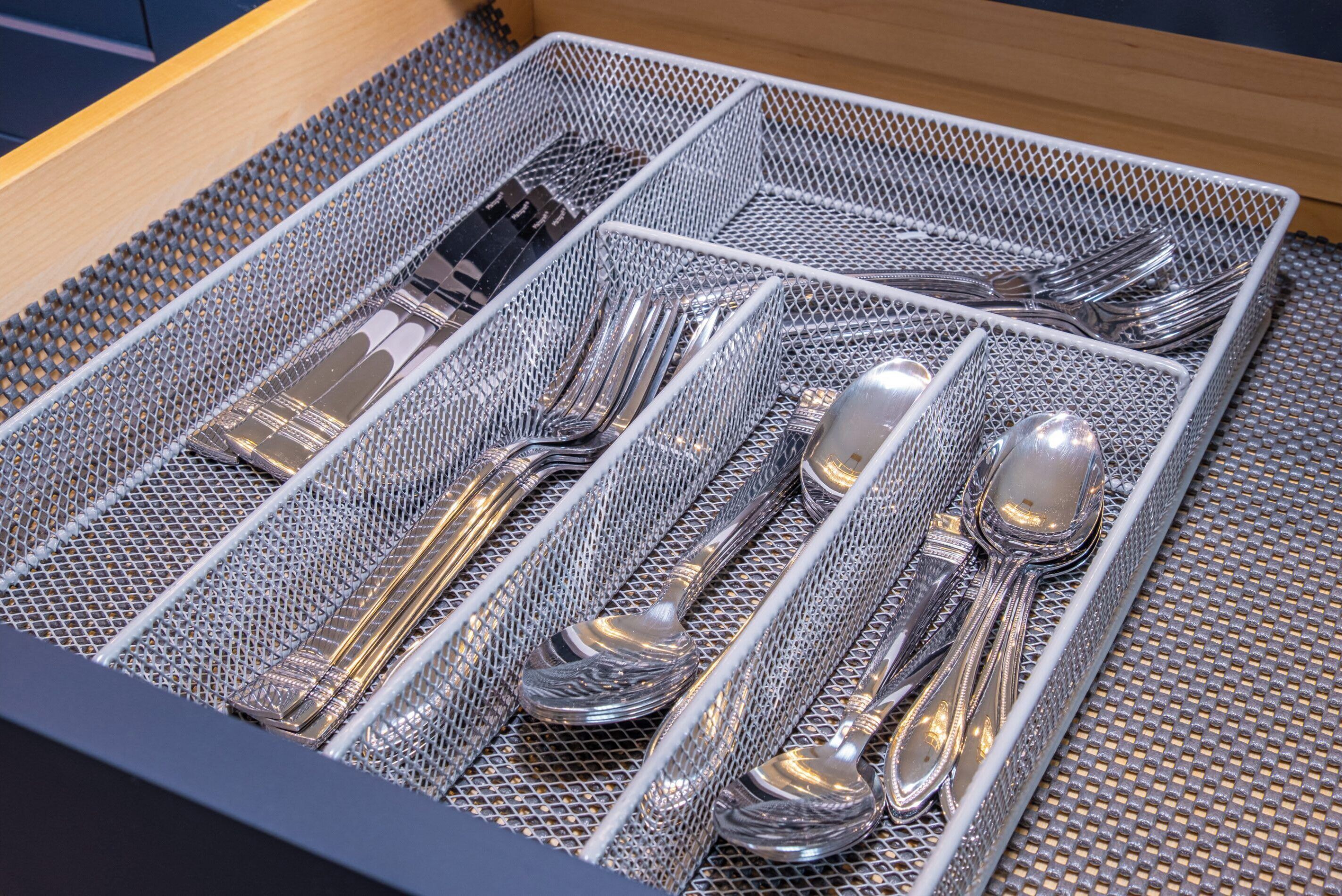 A drawer with neatly arranged silverware including forks, knives, and spoons.