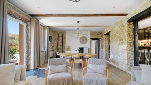 A spacious living area with a wooden dining table, two armchairs, and a sofa. - Holiday Home 'Villa Avec Piscine Soupex' with Private Pool, Private Terrace and Wi-Fi (Soupex)