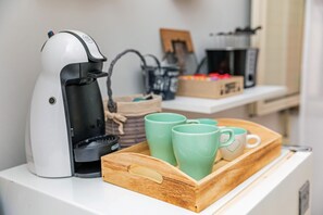 A coffee maker on a counter with a tray of green mugs. - Apartment 'Casa Idda' with Mountain View and Wi-Fi (Linguaglossa)
