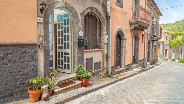 A historic building with a stone facade, arched windows, and a cobblestone street.