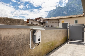 Un bâtiment doté d’un mur en béton, d’une porte en métal et ayant une chaîne de montagnes en arrière-plan.
