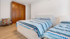 A bedroom with a bed, a wardrobe, and a chair.