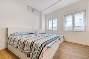 Une chambre à coucher avec un lit, une fenêtre et un appareil de climatisation.