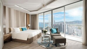 Een moderne hotelkamer met een groot bed, een slaapbank en uitzicht op de stad.