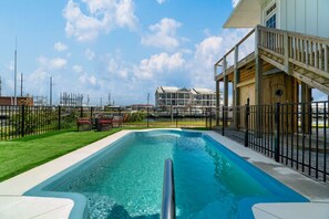 A swimming pool with a wooden deck and a fenced area. - Sea Salt Cottage with private boat dock (Atlantic Beach)
