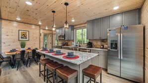 A modern kitchen with a large island, stainless steel appliances, and wooden ceiling. - 3 levels of Luxury*Modern*Private Pool*Stunning Views (SEVIERVILLE)