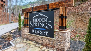 A sign for Hidden Springs Resort with a mountain logo, a pool symbol, and the resort name. - Near Dollywood*Easy Access Roads*Jacuzzi*Pool Table (SEVIERVILLE)