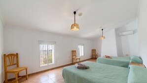 A room with two beds, a wooden chair, a window, and a ceiling light fixture. - Holiday Home 'Casa Rural Las Cales' with Mountain View, Private Pool and Wi-Fi (VELEZ-RUBIO)