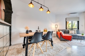 Una sala de estar moderna con comedor, un sofá y una chimenea.