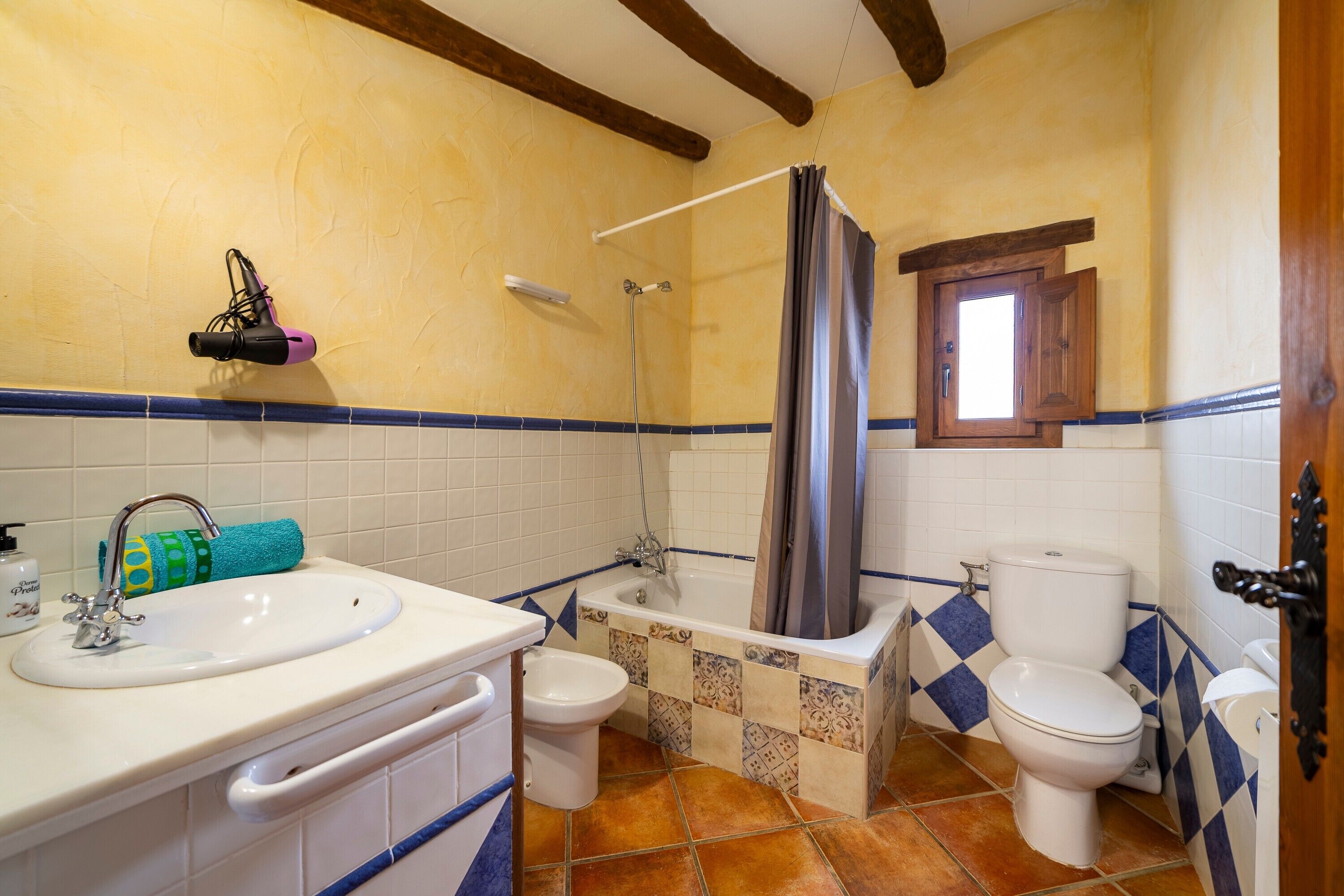 Une salle de bain équipée d’un lavabo, de toilettes, d’une baignoire et d’une douche.