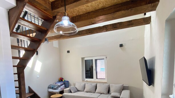 A spacious living area with a wooden staircase, a large sectional sofa, and a ceiling fan. - Beautiful place  on the beach with gorgeous views, close to the restaurants. (Vinišce)